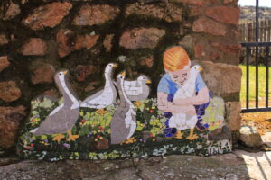 Un menor del pueblo abrazando a patos